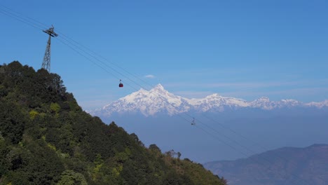 Seilbahnen,-Die-Die-Straßenbahn-Auf-Der-Seite-Eines-Hügels-Mit-Den-Himalaya-Bergen-Im-Hintergrund-Hinauf-Und-Hinunter-Fahren
