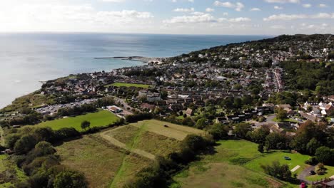 Luftaufnahme-über-Felder-Mit-Blick-Auf-Die-Stadt-Lyme-Regis-Im-Hintergrund