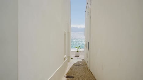 Beautiful-footage-of-the-ocean-through-an-alley-in-Salema
