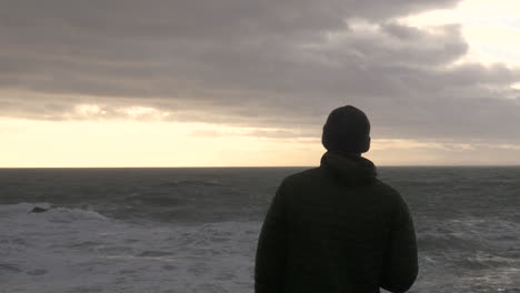 Depressed-Man-Overlooks-Stormy-Sea-At-Sunset