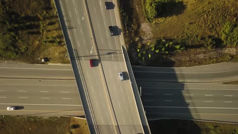 Birds-eye-view-following-traffic-on-a-highway-overpass