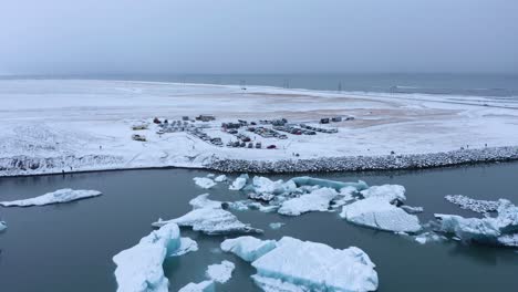 Icebergs-floating-in-the-Jökulsárlón-Glacial-Lagoon,-Vatnajökull-National-Park,-south-coast-of-Iceland---aerial-pullback