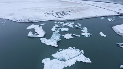 Icebergs-at-the-Glacier-Lagoon-Jökulsárlón-in-Iceland,-Europe---aerial-drone-shot