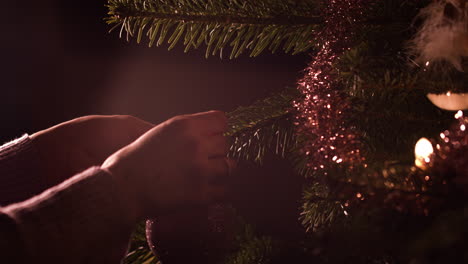 Frauenhände-Hängen-Ornament-Ball-Dekoration-Am-Weihnachtsbaum