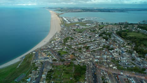 Aerial-view-over-Isle-of-Portland,-Chesil-Beach-and-Fleet-Lagoon-towards-Weymouth-on-the-horizon