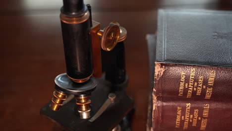 Viejos-Libros-Veterinarios-Antiguos-Y-Un-Microscopio-Vintage---Cierre-Aislado