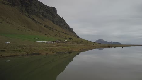 Drone-footage-of-a-mountainside-in-Iceland-with-its-reflection-on-a-lake
