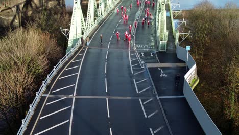Charity-Santa-dash-fun-run-over-Runcorn-Silver-Jubilee-bridge-Aerial-view-descending-tilt-up
