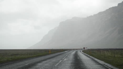 Auto,-Das-Im-Regen-In-Zeitlupe-Die-Nasse-Isländische-Straße-Hinunterfährt
