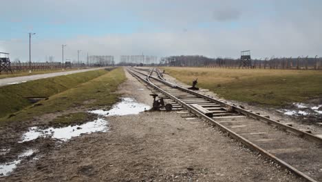 Blick-Auf-Die-Gleise-Des-Konzentrationslagers-Auschwitz,-Während-Leichte-Schneeflocken-Fallen
