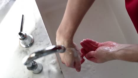 Top-Down-View-Of-Man-Washing-Soap-Off-Hands-In-Slow-Motion