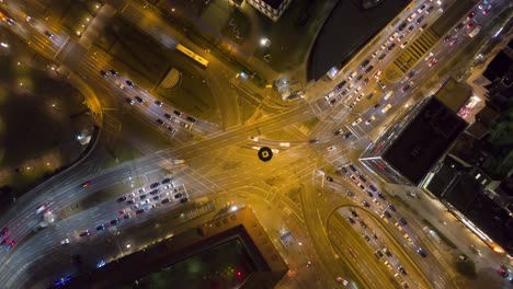 Aerial-top-down-night-time-lapse-of-huge-busy-intersection-with-traffic-and-cars-passing-by-with-motion-blur-in-Stuttgart,-Germany-in-4k