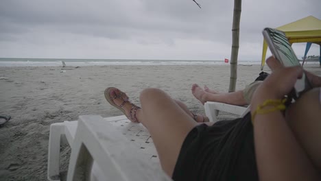 Frau,-Die-Sich-Auf-Sonnenliege-Entspannt-Und-Sturmwolken-über-Dem-Ozean-Beobachtet,-Equador-Beach