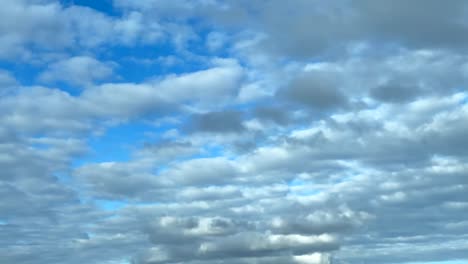 Weiße-Kumuluswolken,-Die-Sich-Harmonisch-Bewegen-Und-Licht-Und-Schatten-über-Einen-Blauen-Himmelshintergrund-Werfen
