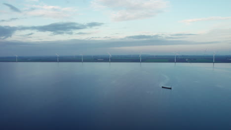 Jenseitiger-Seeblick-Mit-über-Den-Horizont-Verstreuten-Windrädern