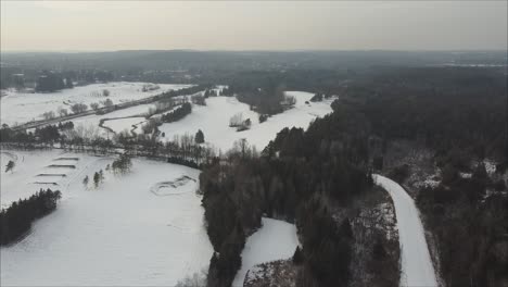 Aerial-Flyover-Of-A-Frozen-Snow-Covered-Golf-Course-In-Caledon,-Canada