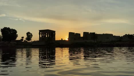 Beautiful-ode-of-love-Philae-temple-at-sunset-light-the-beautiful-temple-of-Philae-and-the-Greco-Roman-buildings-are-seen-from-the-Nile-river-a-temple-dedicated-to-Isis,-goddess-of-love-Aswan-Egyptian