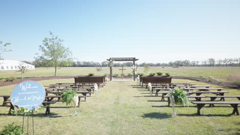 Wedding-ceremony-set-up-outdoors-tracking-forward-through-pews-towards-cross