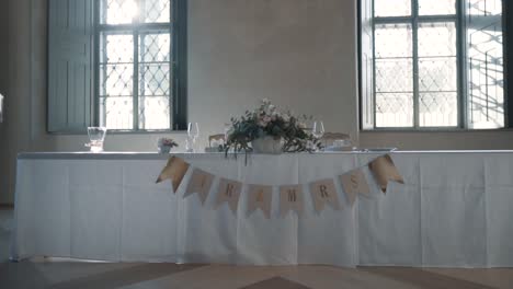White-wedding-table-for-a-newly-married-couple-with-a-flower-and-Mr-and-Mrs-signs