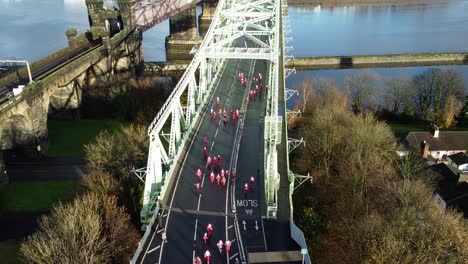 Charity-Santa-dash-fun-run-over-Runcorn-Silver-Jubilee-bridge-Aerial-view-rising-forwards