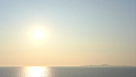 A-bright-yellow-sun-just-above-the-horizon-reflects-in-the-ocean