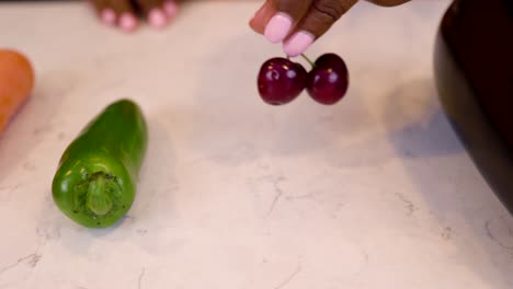 black-woman-hand-is-seductively-grabbing-cherry-vegetables-on-a-marble-kitchen-table