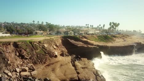 Aerial-flying-over-pacific-ocean-cliffs-towards-condos-on-the-San-Diego-shore