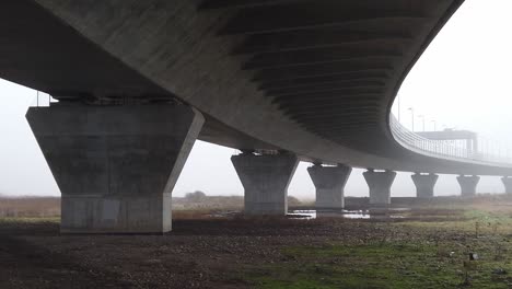 Ghostly-misty-concrete-support-structure-under-motorway-flyover