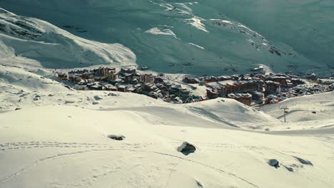 Beautiful-Val-Thorens-ski-resort-with-chalets-down-mountainside,-aerial-view