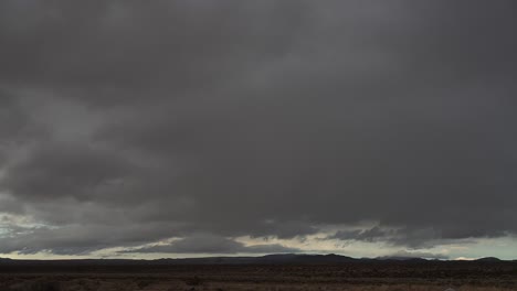 Storm-clouds-form-over-the-Mojave-Desert's-arid-landscape-then-rain-pours-down-in-a-heavy-cloudburst---time-lapse