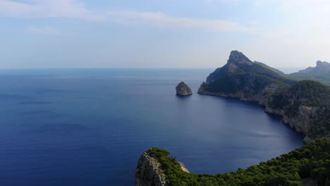 Aerial-Panoramic-View-Of-Forested-Cliffs-Of-Cap-De-Formentor-With-Vast-Calm-Blue-Ocean-In-The-Background