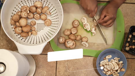 Slicing-fresh,-organic-mushrooms-in-preparation-to-making-vegan-soup---overhead-view-WILD-RICE-SERIES