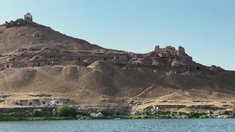 Vista-Fantástica-Desde-Un-Crucero-Por-El-Río-Nilo,-Sobre-El-Desierto-Con-Vistas-A-Las-Tumbas-Nubias-Y-Los-Templos-Antiguos