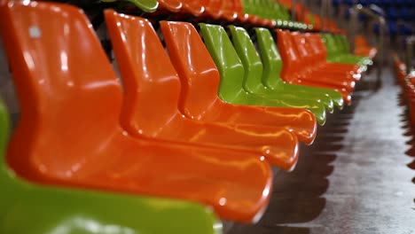 Rows-of-green-and-orange-stadium-chairs