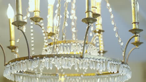 Vintage-chandelier-hanging-from-ceiling-with-modern-LED-light-bulbs