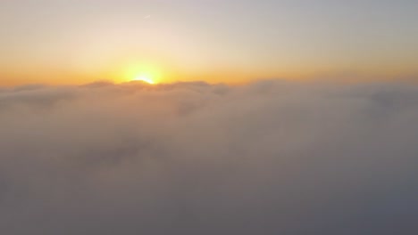 4k-drone-footage-from-above-the-clouds-while-sunrise