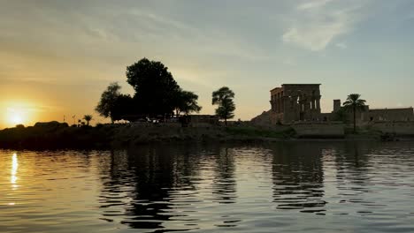 Beautiful-Philae-temple-of-love-at-sunset-light-the-beautiful-temple-of-Philae-and-the-Greco-Roman-buildings-are-seen-from-the-Nile-river-a-temple-dedicated-to-Isis,-goddess-of-love-Aswan-Egyptian