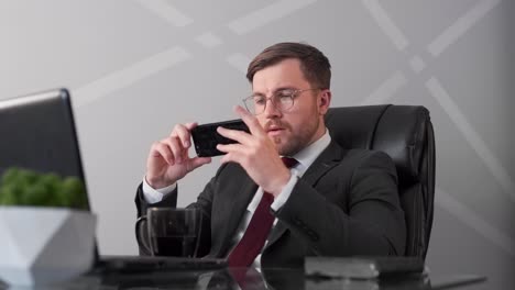 Business-man-watching-exciting-video-on-phone