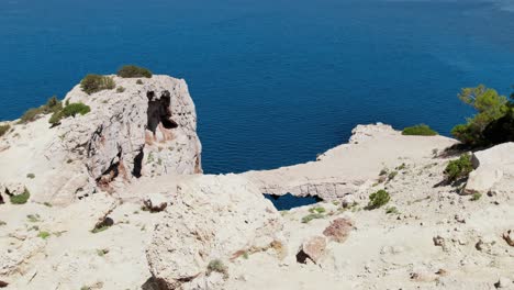 Drone-shot-flying-over-cliffs-and-mountains-on-coast-of-Ibiza-Island