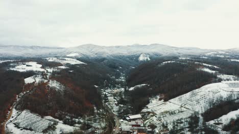 Aerial-view-of-the-snowy-village-in-the-valley,-Drone-4K