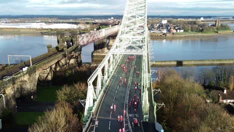 Charity-Santa-dash-fun-run-over-Runcorn-Silver-Jubilee-bridge-Aerial-view-slow-descend