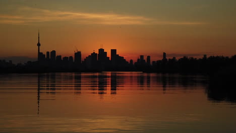 Slow-motion-magic-hour-shot-of-Toronto-skyline-silhouetted-against-an-orange-sky