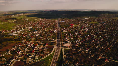 Vista-De-Pájaro-De-La-Carretera-Con-Tráfico-Vehicular-En-Medio-Del-Campo-Asentamiento-Humano