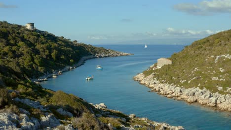 Costa-De-La-Isla-Paxi-Con-Barcos-En-Laguna-Tropical-En-Grecia,-Antena