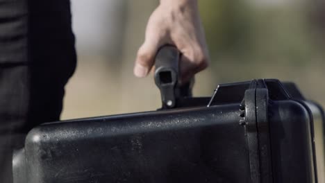 Close-up-slow-motion-clip-of-a-man-carrying-a-heavy-duty-gear-case