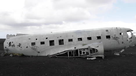 Tilting-Up-Shot-of-an-Old-Crashed-Plane-on-an-Iceland-Volcanic-Beach-in-Slow-Motion