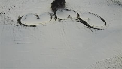 Rising-Aerial-Shot-Of-Snow-Covered-Bunker-And-Fairway-On-A-Golf-Course