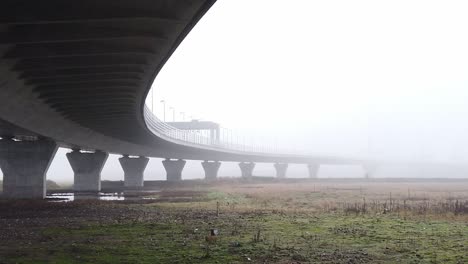 Ghostly-misty-concrete-support-structure-under-motorway-flyover-right-pan