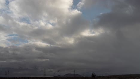Wolkengebilde-über-Der-Mojave-Wüstenlandschaft,-Bergen-Und-Hochspannungsmasten---Statischer-Weitwinkel-Zeitraffer