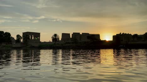 Beautiful-Philae-temple-at-sunset-light-the-beautiful-temple-of-Philae-and-the-Greco-Roman-pylons-are-seen-from-the-Nile-river-a-temple-dedicated-to-Isis,-goddess-of-love-Aswan-Egyptian